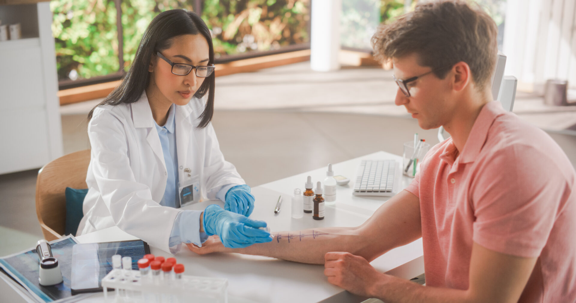 Female allergy specialist conducting an allergy test on the arm of an adult male patient. 